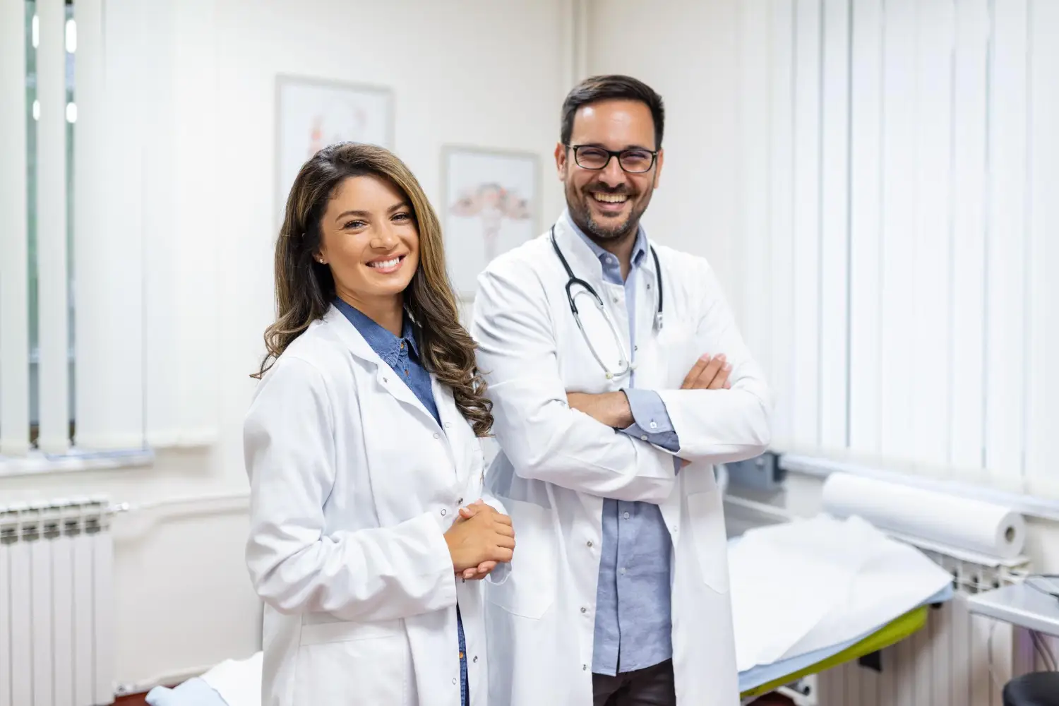Retrato de jovens médicos sorridentes em pé juntos; retrato da equipe médica no interior.